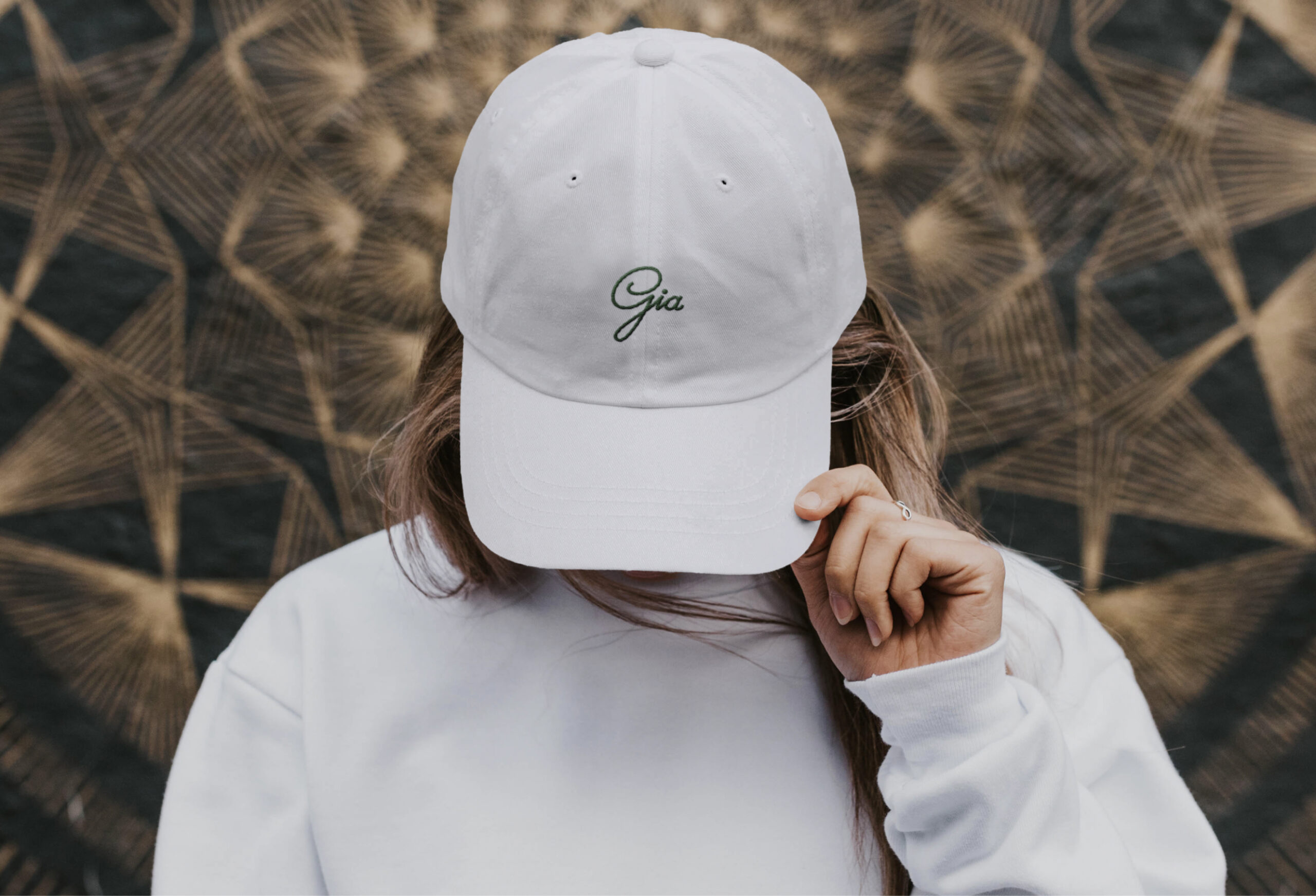 Woman wearing a Gia branded dad hat. 